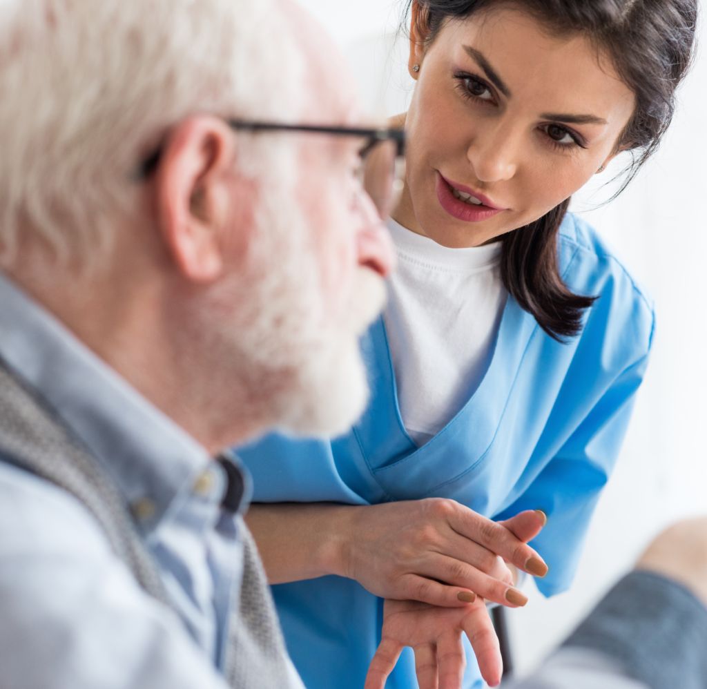 Selective focus of calm nurse talking to elderly patient